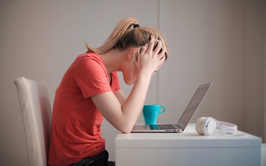 woman in orange shirt looking stressed