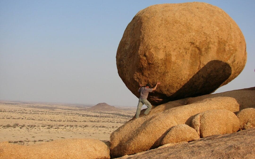 man standing beside rock formation