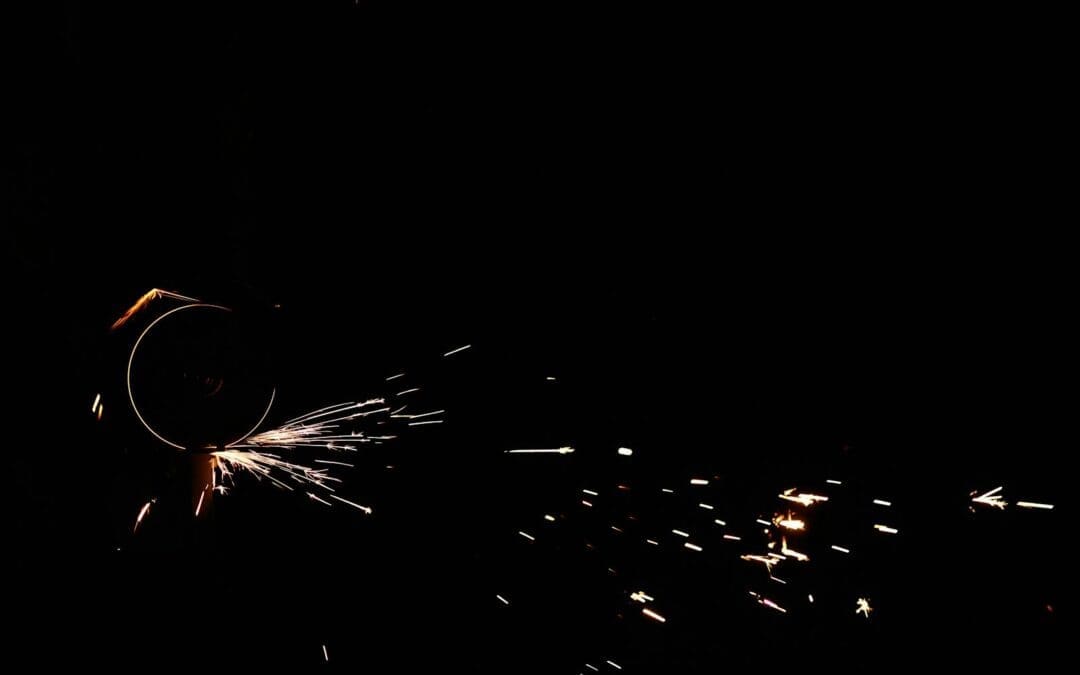 Close-up of an angle grinder creating vibrant sparks against a dark background.